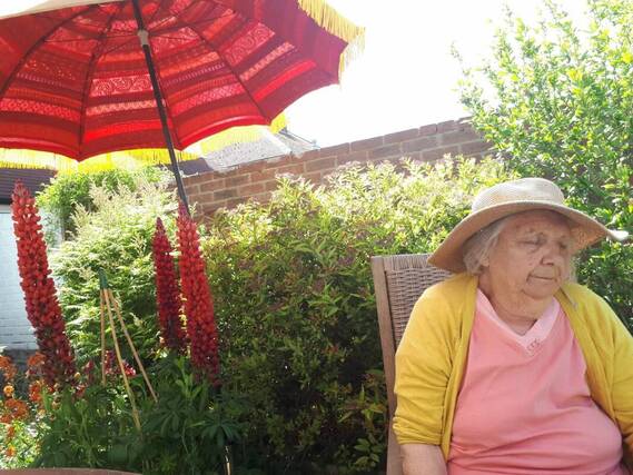 Photo of the author's mother in the sunshine in her garden